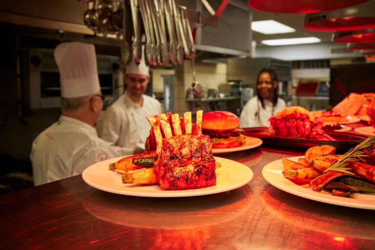 three chefs with food on the counter in the foreground