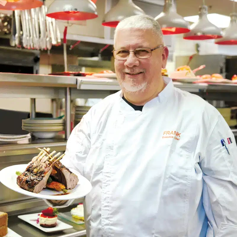 Chef at Peace Village presenting a dish